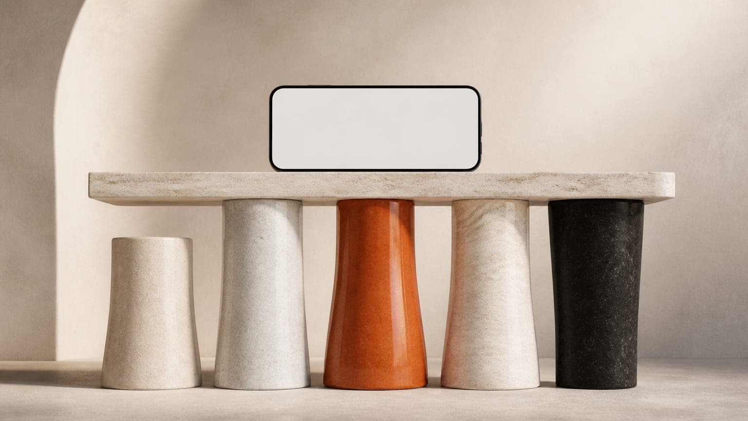 Five stone columns of slightly different heights supporting a flat slab with a blank phone resting on top, one column burnt orange